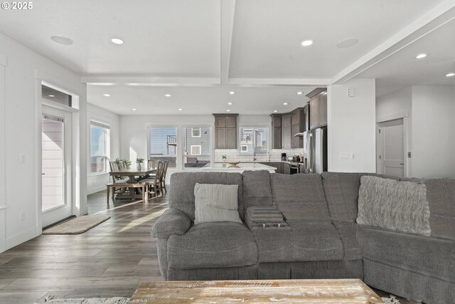 living room with dark wood-type flooring and beam ceiling