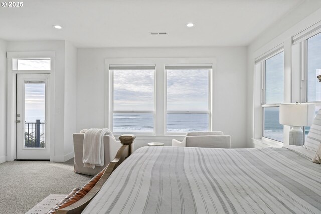 carpeted bedroom with a water view and access to outside