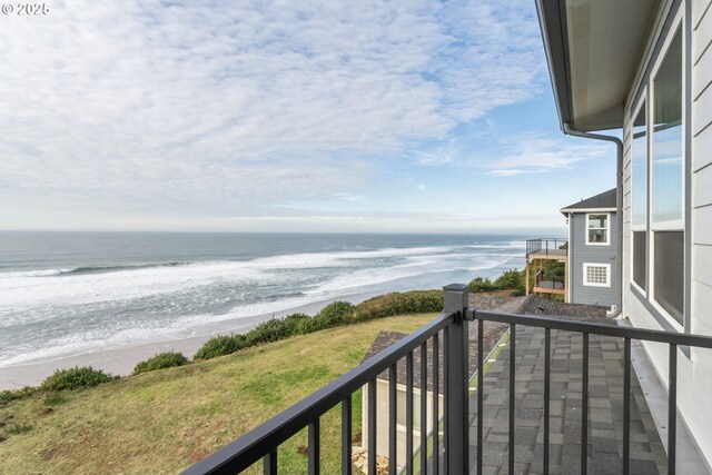 balcony with a water view and a view of the beach