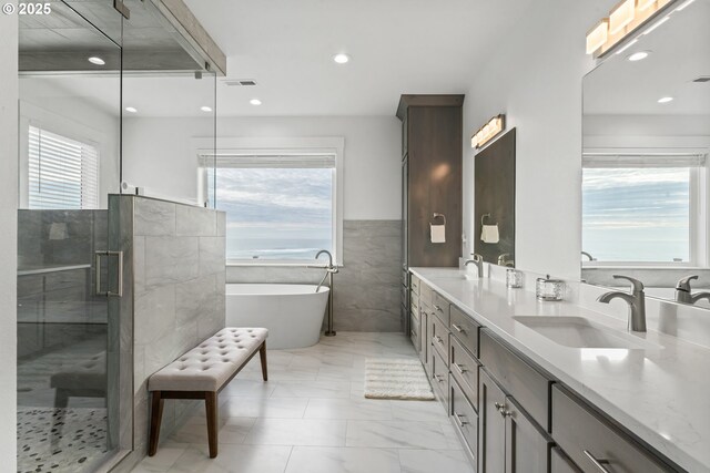 bathroom featuring vanity, separate shower and tub, and tile walls