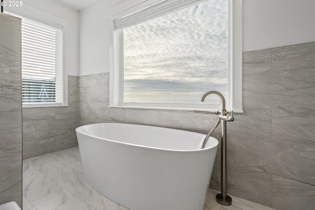 bathroom featuring a bathing tub and tile walls