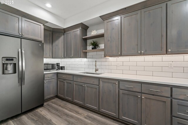 kitchen with sink, dark wood-type flooring, decorative backsplash, and stainless steel fridge with ice dispenser