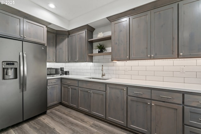 kitchen with appliances with stainless steel finishes, sink, dark hardwood / wood-style floors, and decorative backsplash