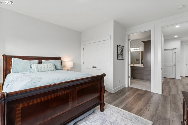 bedroom with wood-type flooring, connected bathroom, and a closet