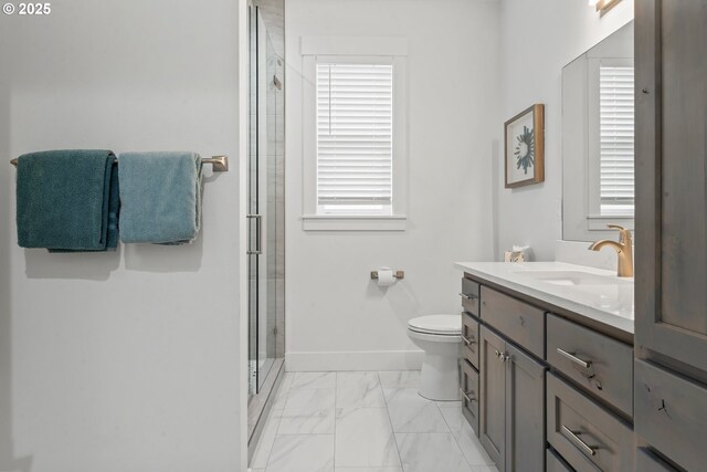 bathroom featuring a shower with door, vanity, and toilet