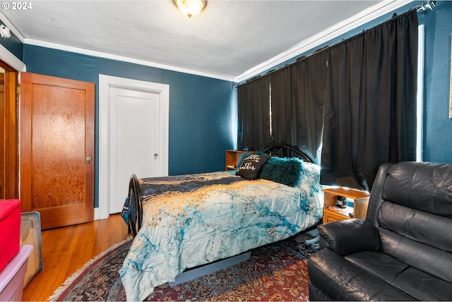 bedroom featuring hardwood / wood-style flooring and crown molding