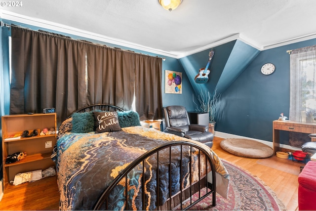 bedroom featuring vaulted ceiling, baseboards, and wood finished floors