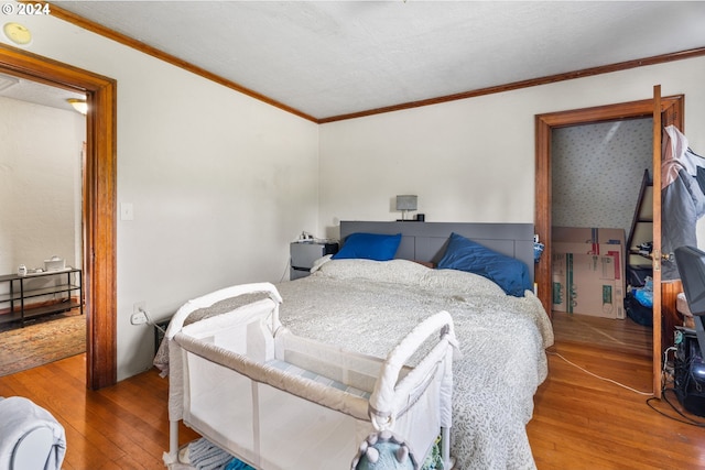 bedroom featuring wood-type flooring and crown molding