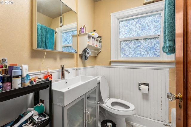 bathroom featuring wainscoting, vanity, and toilet