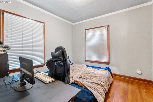 bedroom with crown molding, light hardwood / wood-style flooring, and a textured ceiling