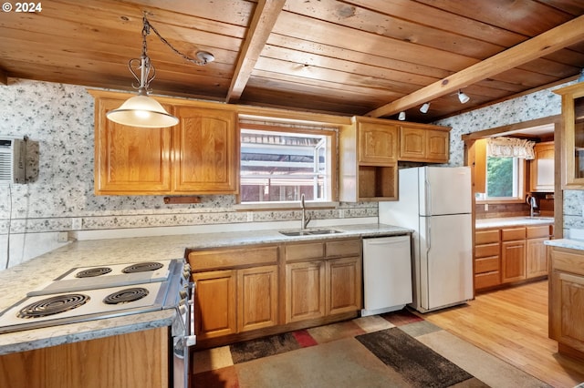 kitchen with white appliances, sink, pendant lighting, light wood-type flooring, and beam ceiling