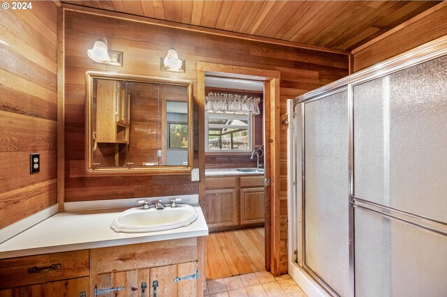 bathroom featuring a shower with door, wooden walls, vanity, hardwood / wood-style floors, and wooden ceiling