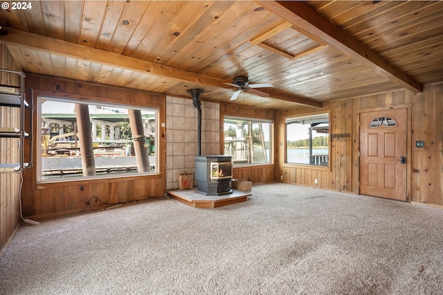 unfurnished living room with beamed ceiling and wooden walls