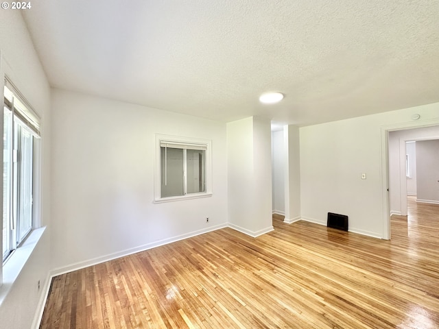 empty room featuring light hardwood / wood-style floors and a textured ceiling