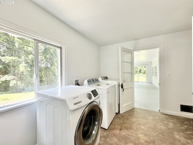 laundry area featuring washing machine and dryer and a textured ceiling