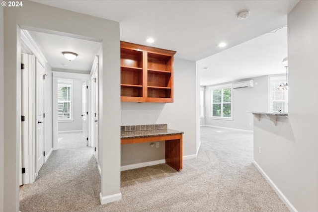 hallway with light carpet and a wall mounted air conditioner