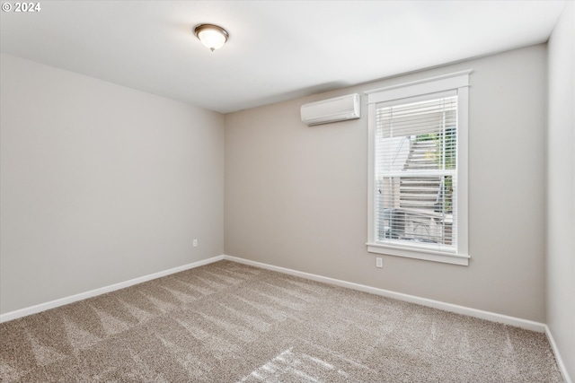 carpeted spare room featuring an AC wall unit