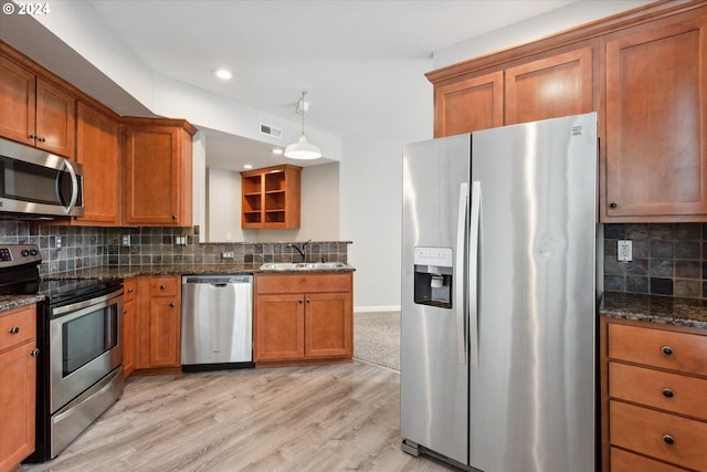 kitchen with light hardwood / wood-style flooring, stainless steel appliances, backsplash, and sink