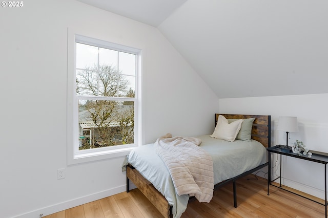 bedroom featuring light wood-type flooring and vaulted ceiling