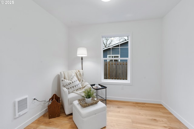 sitting room featuring hardwood / wood-style floors and heating unit