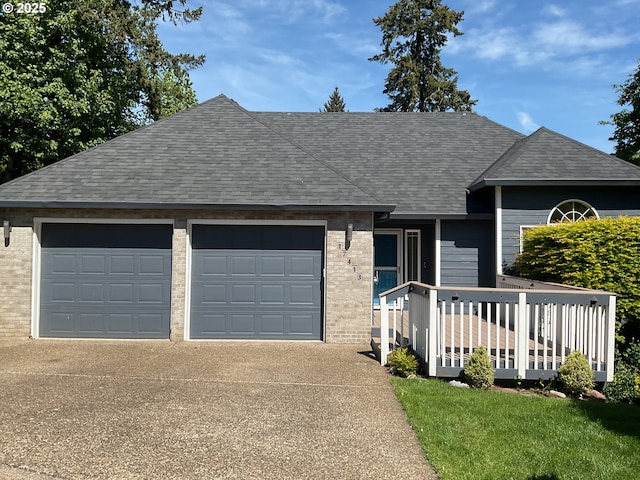 view of front of property with an attached garage, concrete driveway, roof with shingles, and brick siding