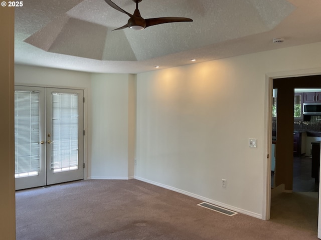 empty room with carpet floors, french doors, a textured ceiling, a ceiling fan, and recessed lighting