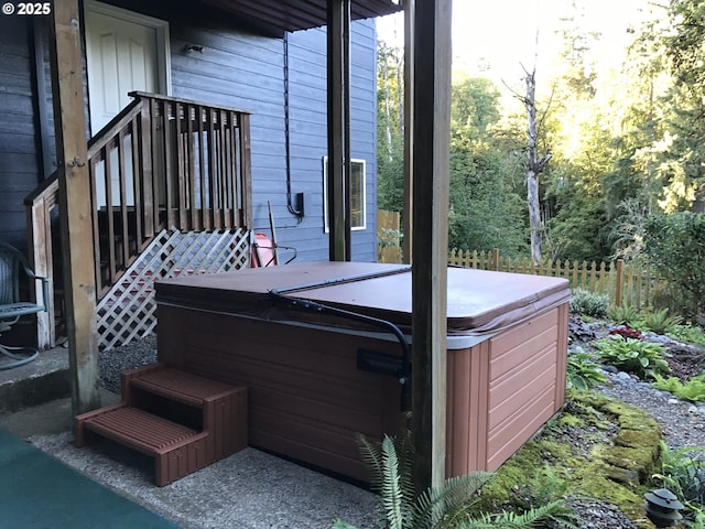 wooden deck with a hot tub and fence