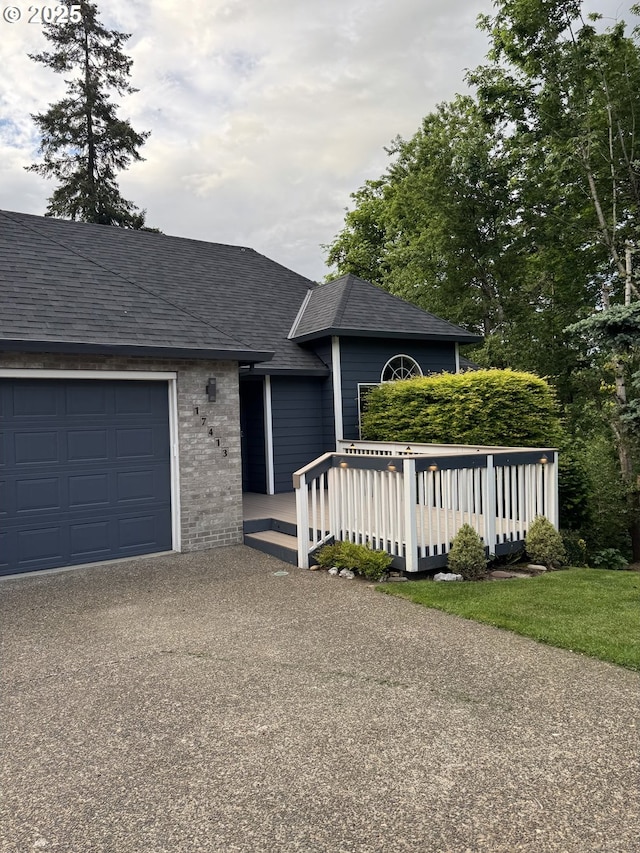 ranch-style house with an attached garage, asphalt driveway, a shingled roof, and a deck