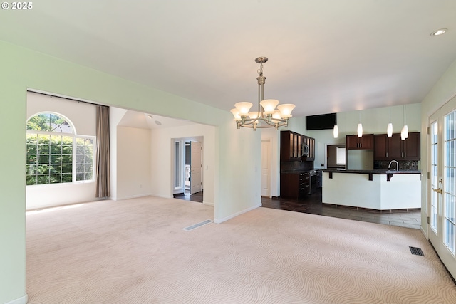 17413 Wake Robin Cir, Oregon City, OR 97045 - kitchen featuring dark colored carpet, a chandelier, dark countertops, a kitchen breakfast bar, and hanging light fixtures