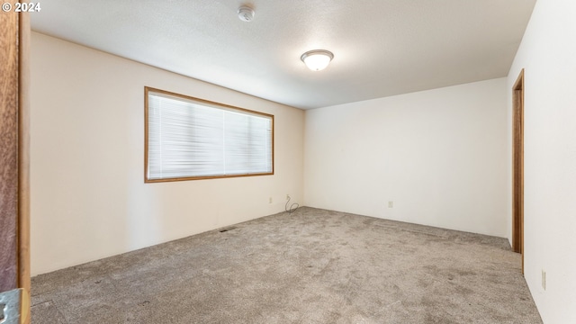 carpeted spare room with a textured ceiling