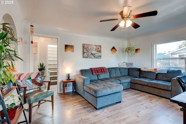 living room with ceiling fan and light hardwood / wood-style flooring