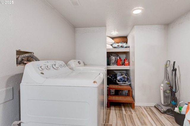 washroom with washer and clothes dryer and light hardwood / wood-style flooring