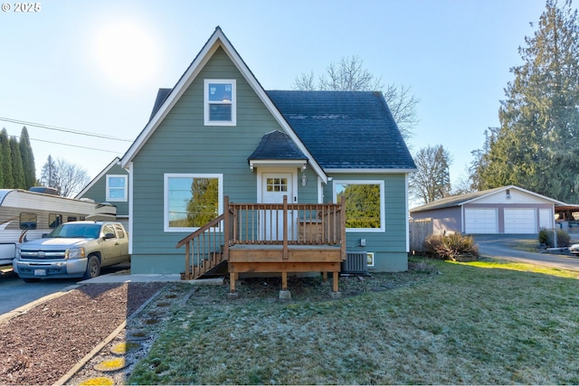 view of front of house with a carport, central AC, a front yard, a garage, and an outbuilding