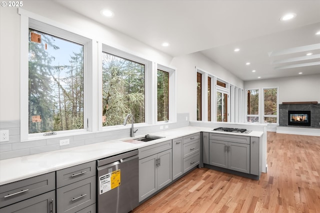 kitchen featuring appliances with stainless steel finishes, gray cabinets, sink, and kitchen peninsula