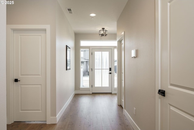 doorway featuring visible vents, recessed lighting, baseboards, and wood finished floors