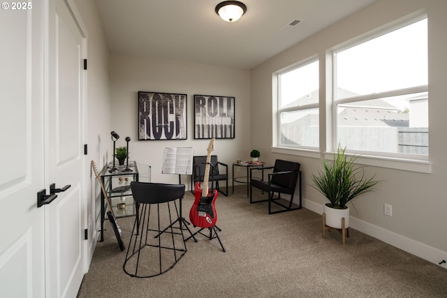 carpeted office space featuring visible vents and baseboards