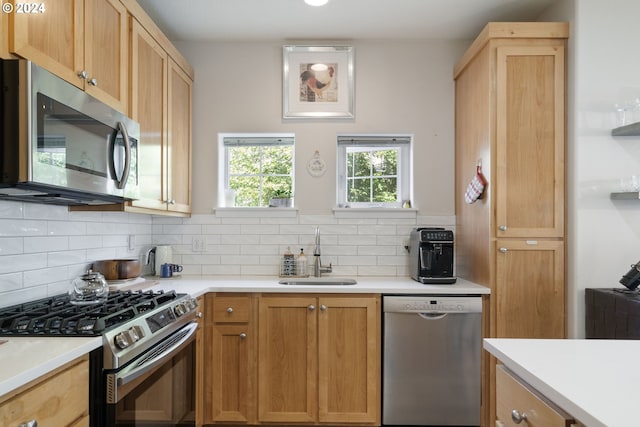 kitchen featuring light brown cabinetry, stainless steel appliances, sink, and decorative backsplash