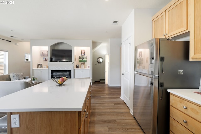 kitchen featuring a kitchen island, stainless steel refrigerator, light brown cabinets, and light hardwood / wood-style floors