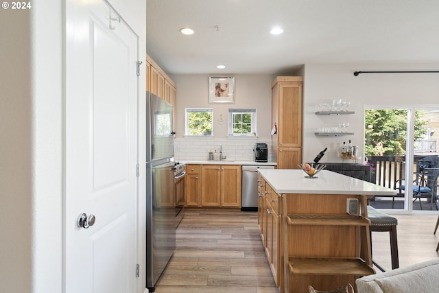 kitchen featuring plenty of natural light, a center island, backsplash, and light hardwood / wood-style floors