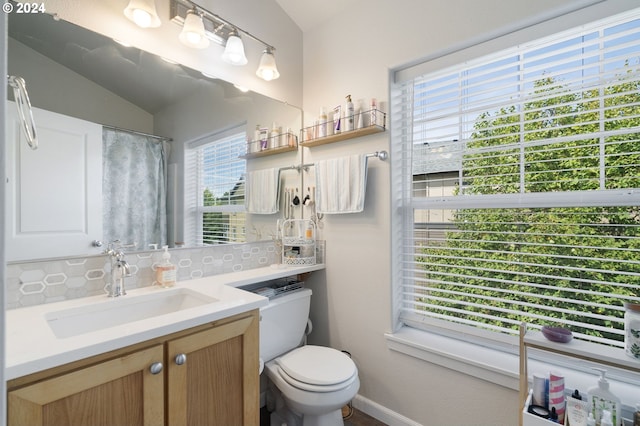 bathroom featuring vanity, vaulted ceiling, and toilet