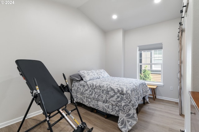 bedroom featuring light wood-type flooring and vaulted ceiling