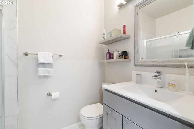 bathroom featuring vanity, toilet, and a shower with shower door