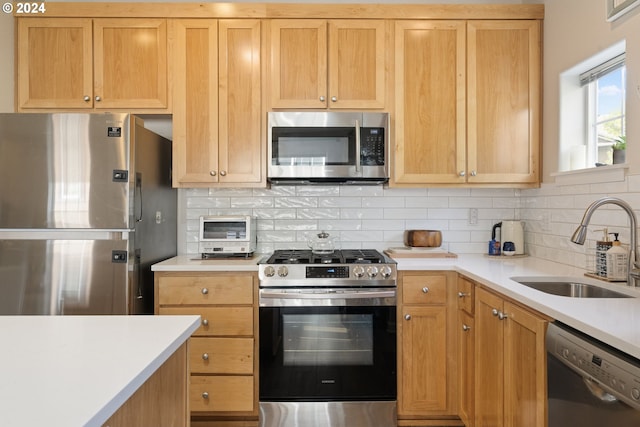 kitchen featuring appliances with stainless steel finishes, backsplash, and sink