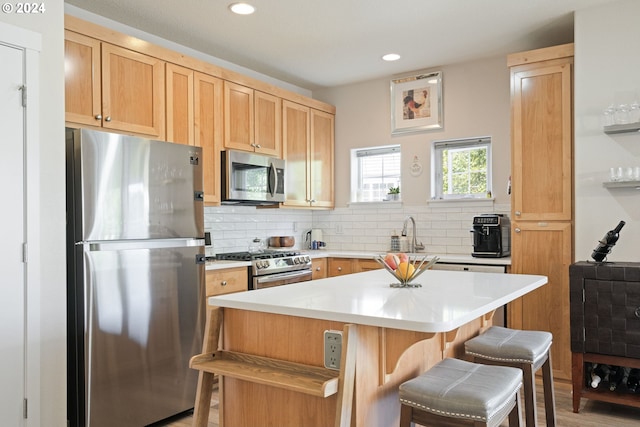 kitchen with light hardwood / wood-style flooring, backsplash, stainless steel appliances, a center island, and a breakfast bar