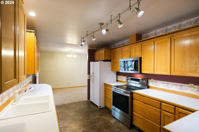 kitchen with baseboards, brown cabinetry, stainless steel appliances, light countertops, and a sink