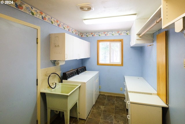 clothes washing area featuring a sink, visible vents, baseboards, independent washer and dryer, and cabinet space