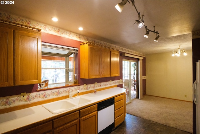 kitchen with sink, dark colored carpet, a notable chandelier, a textured ceiling, and white appliances