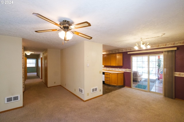 kitchen featuring visible vents, brown cabinetry, and a textured ceiling