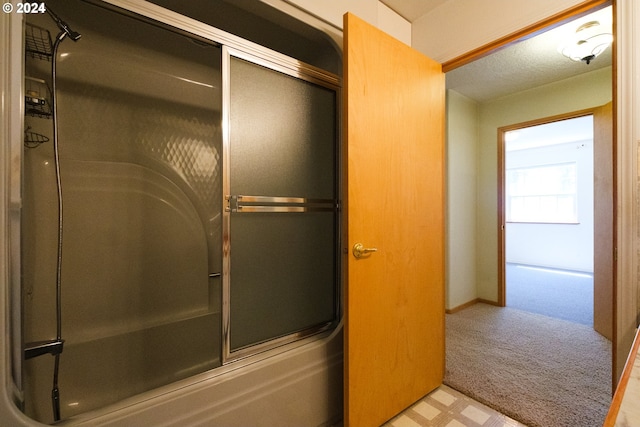 bathroom with bath / shower combo with glass door