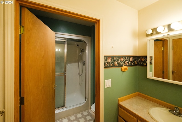 bathroom featuring toilet, a shower stall, vanity, and tile patterned floors